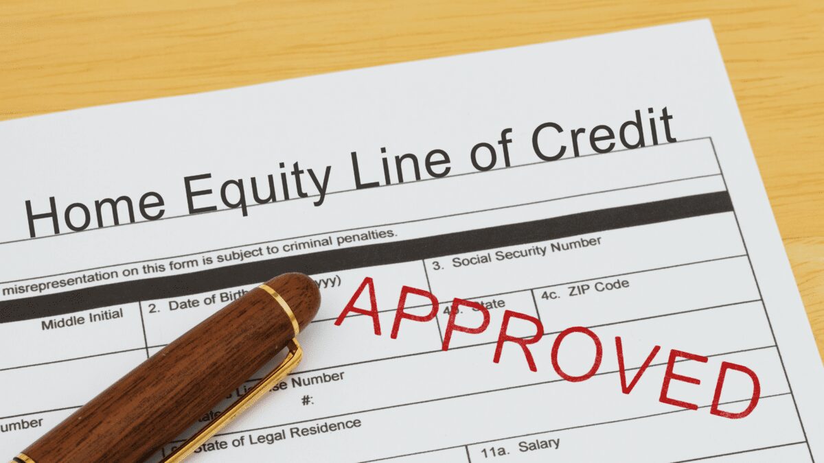 a pen sits on top of approved home equity line of credit paperwork