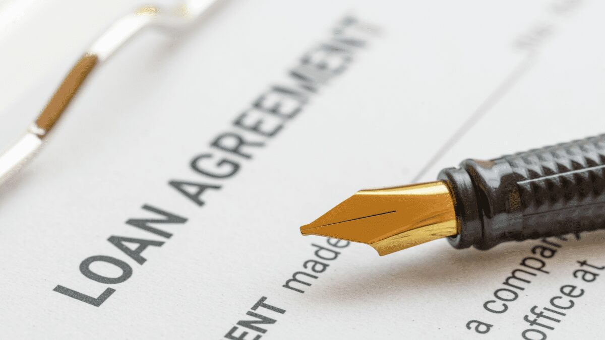 a pen sits on top of a loan agreement