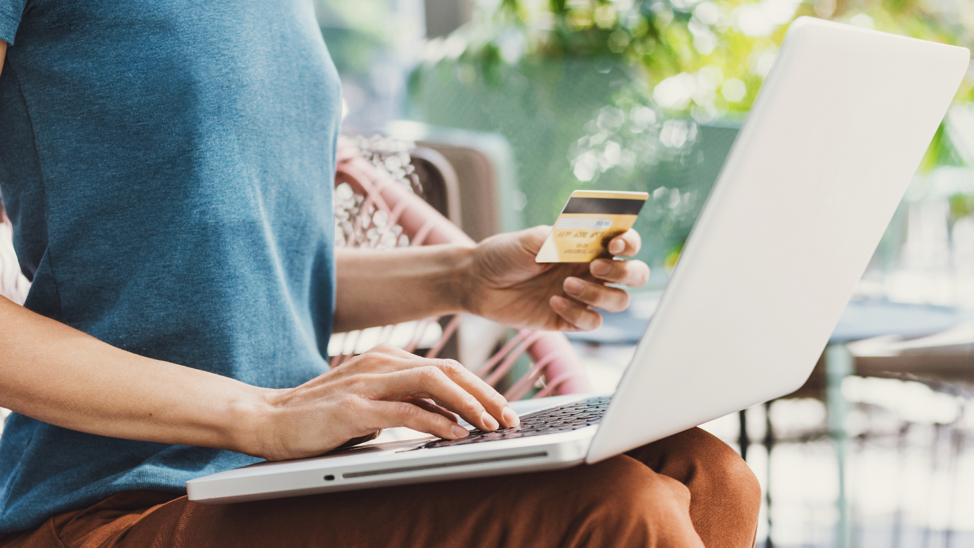 a woman uses a laptop computer to make an online payment with a credit card