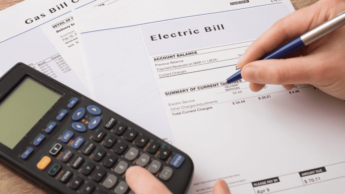 a paper form with electric bill charges sits on a table