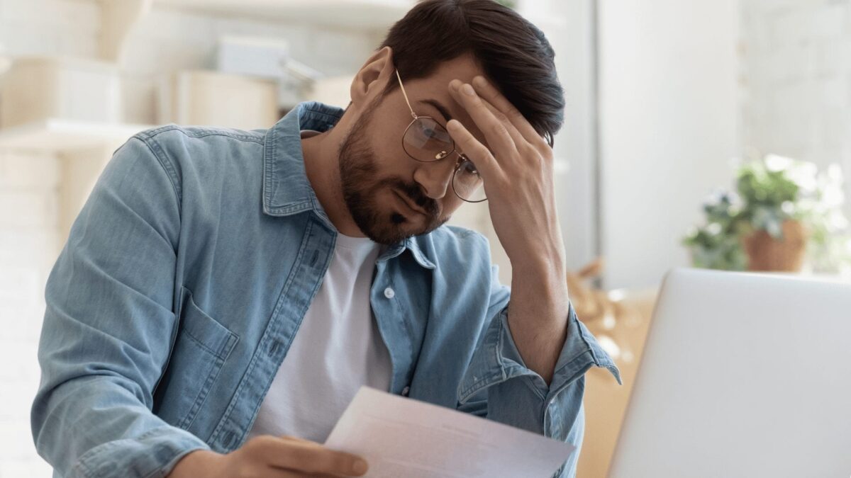 man looking at paperwork with frustration