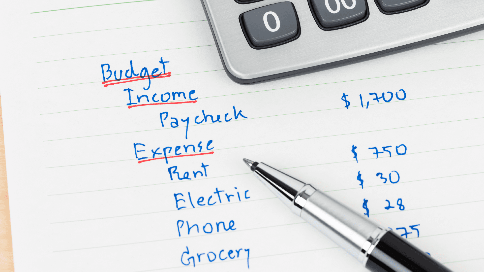 hand writing home budget with calculator