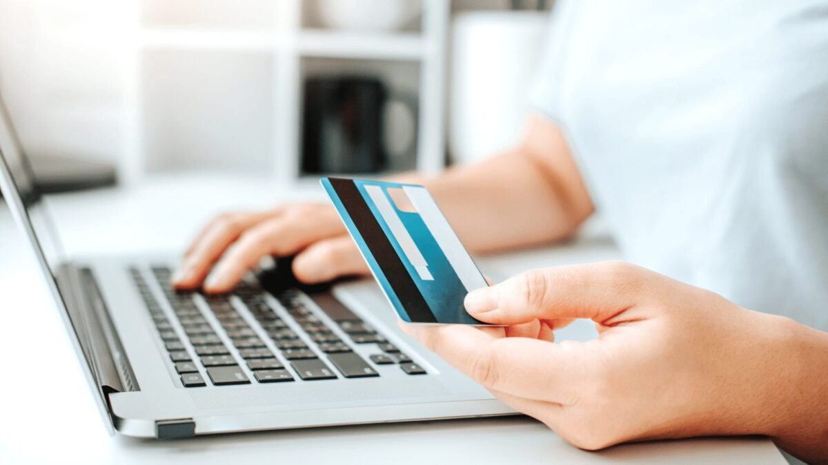 woman browsing internet with credit card in hand