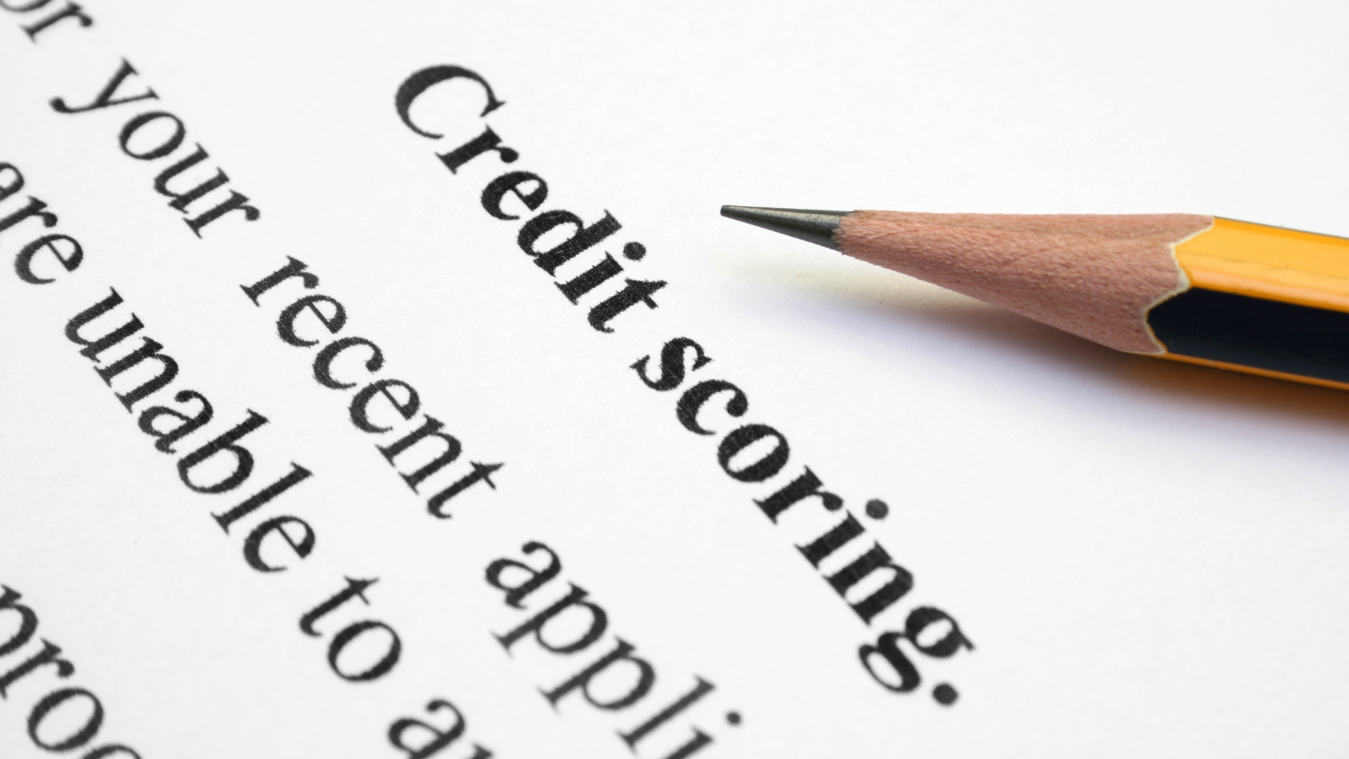 a pencil points to the word “credit scoring” on a piece of paper