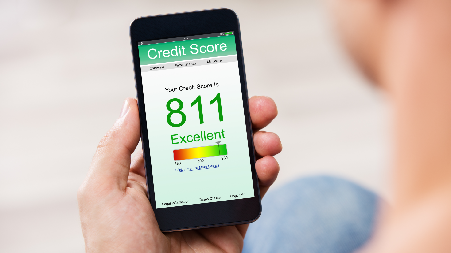 a person holds a smartphone displaying an excellent credit score