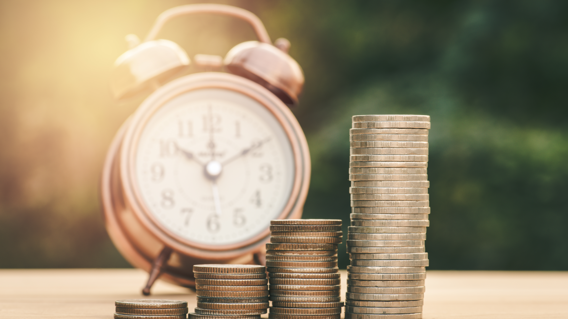 an alarm clock with stacks of coins sitting in front of it