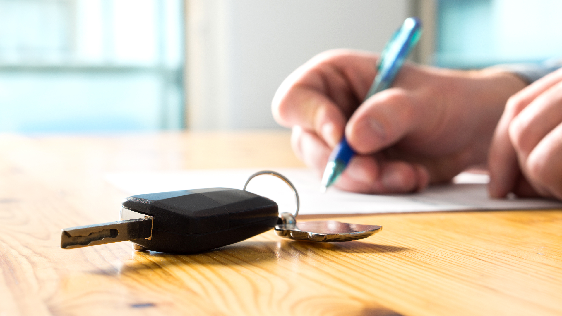 car keys sit next to person filling out paper form