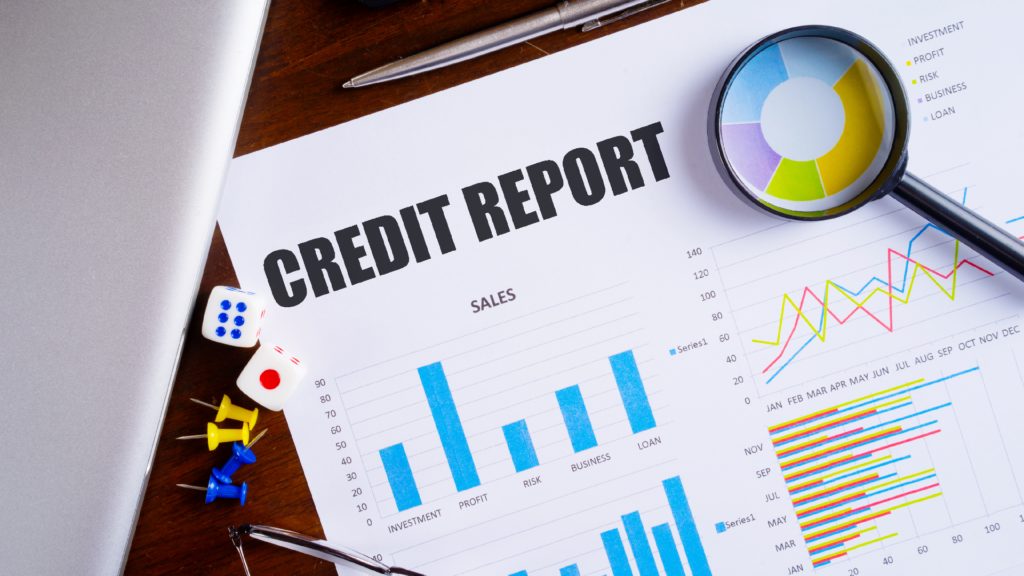 "Credit Report" text on paper sheet with magnifying glass on chart