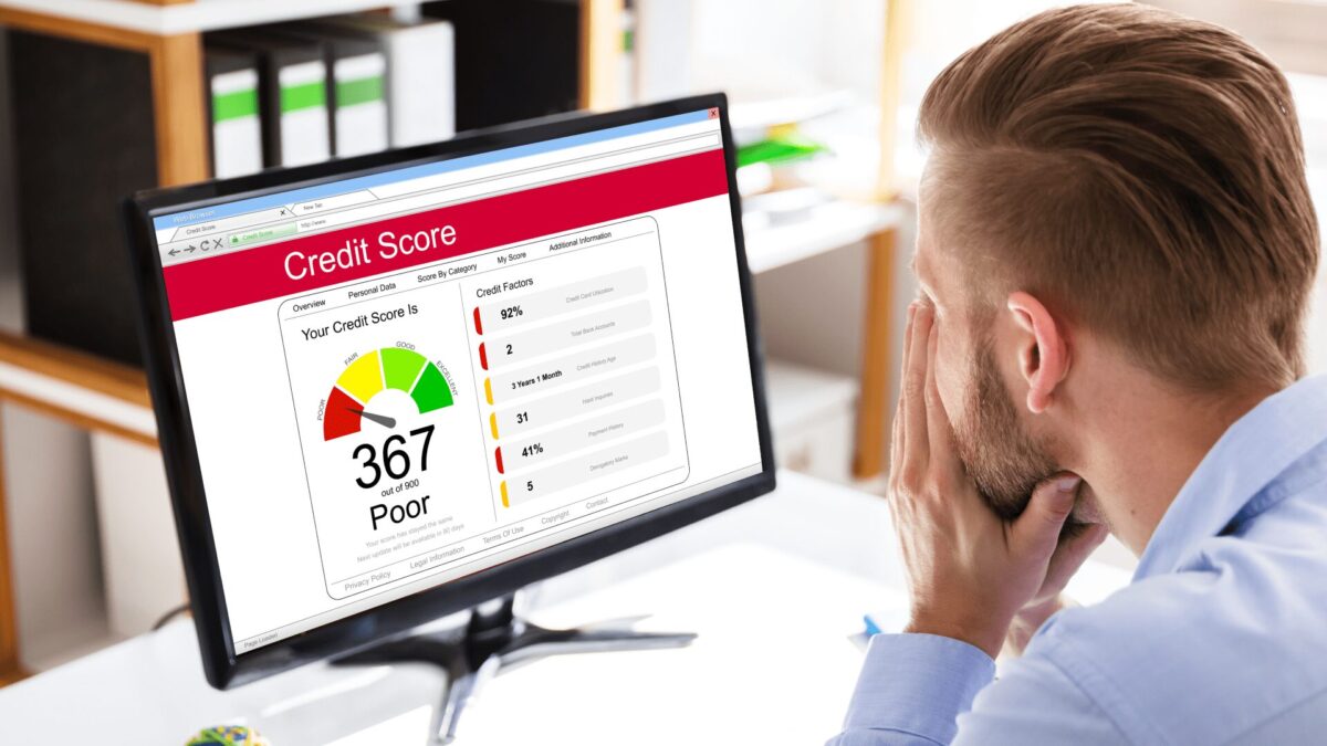 a person looks at their poor credit score on a computer screen