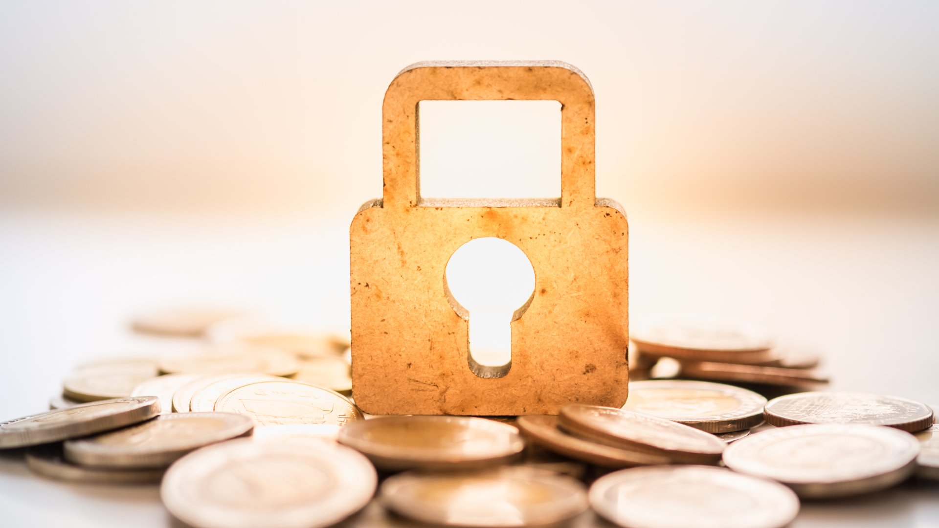 a wooden security lock sits on top of coins to represent a secured loan