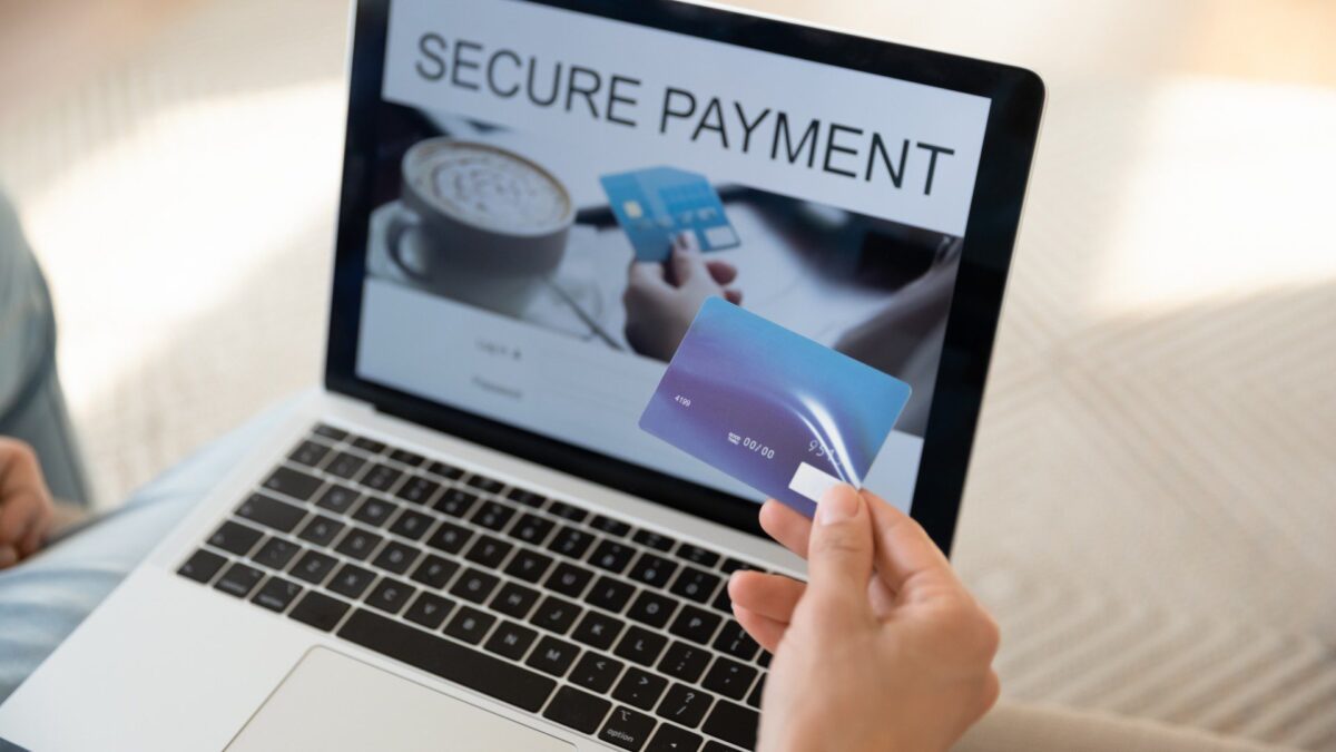 a person makes a secure payment on a laptop after allowing instant bank verification