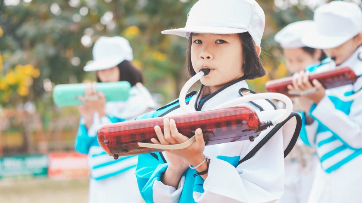 Criança tocando instrumento musical em banda marcial depois que os pais pagam por atividades extracurriculares