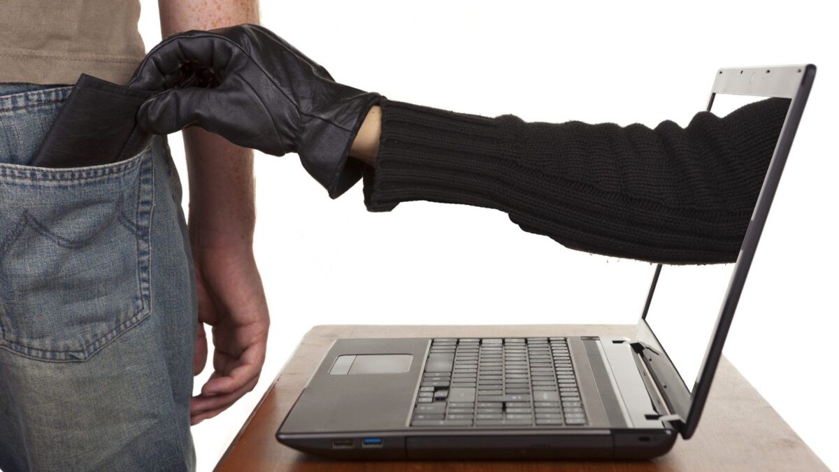 a person’s hand is coming out of a laptop computer to steal a wallet out of someone’s back pocket