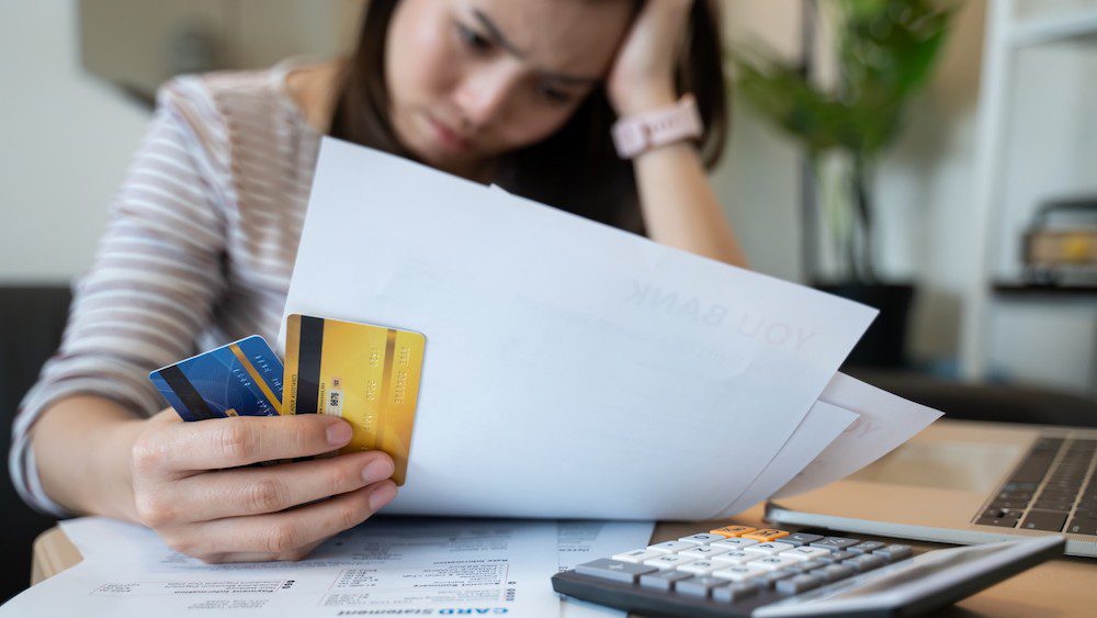 Woman stressfully reviewing financial statements | 9 Tips For Improving Bad Credit | Wise Loan