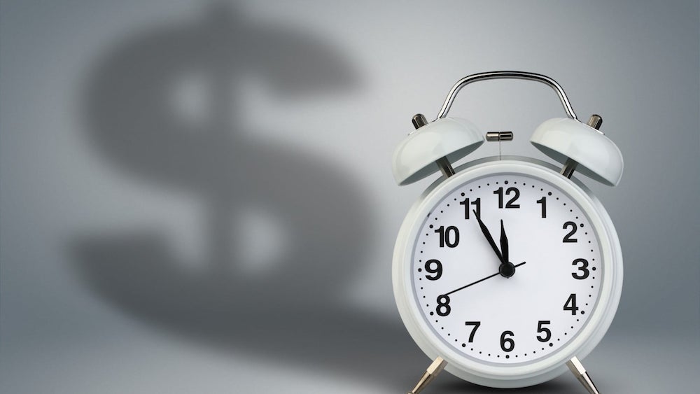 Clock with dollar-sign shaped shadow | Tips for Making Your Installment Payments on Time | Wise Loan