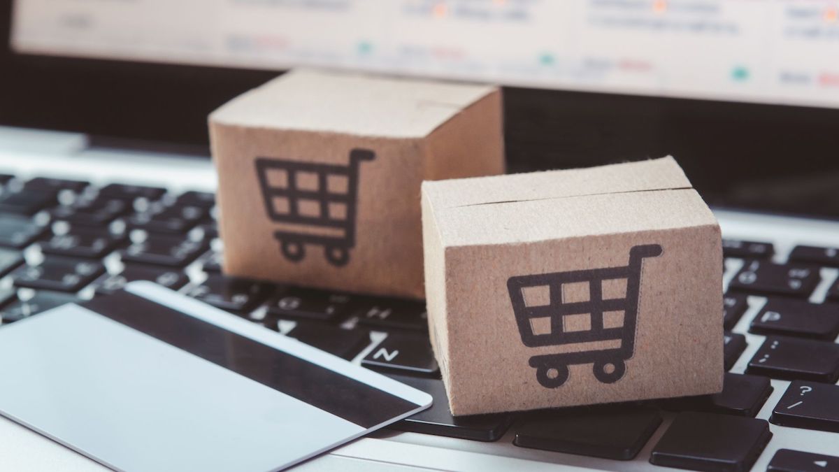 Tiny cardboard boxes with shopping cart logo on top of laptop keyboard | Credit Inquiries | Wise Loan