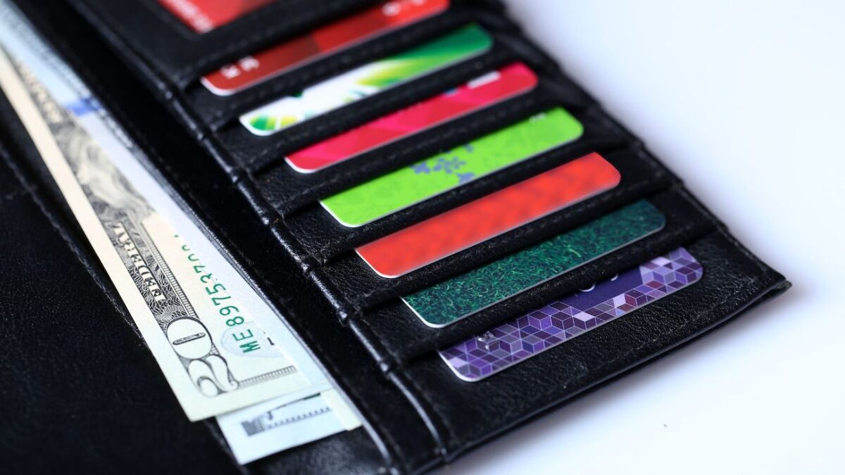 Close up of wallet filled with cash and various credit cards | Wise Loan