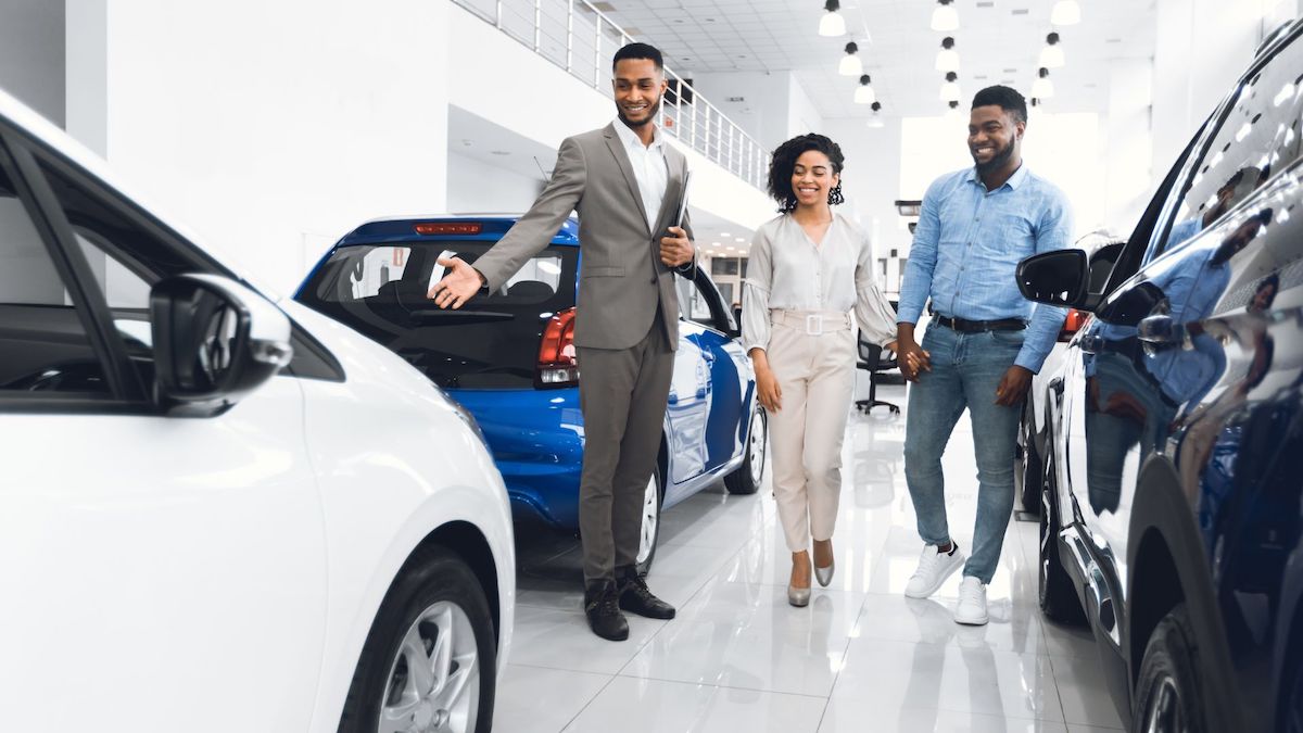 Car salesman showing a couple a new car | Exception of Rate Shopping | Wise Loan