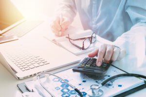 Billing representative is calculating a medical bill on a calculator | Wise Loan