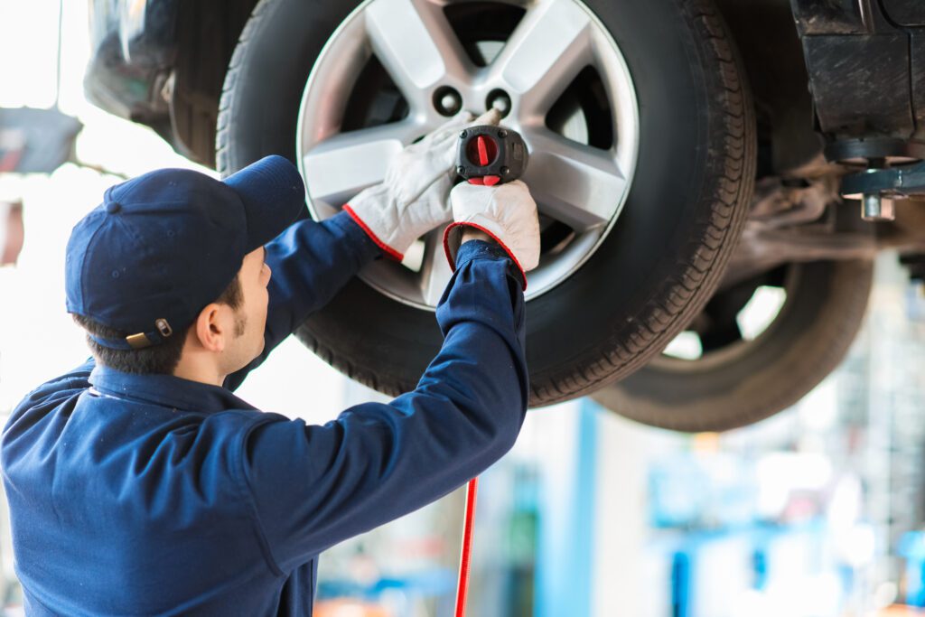 A mechanic fixing a car’s tires | Emergency reasons to borrow money