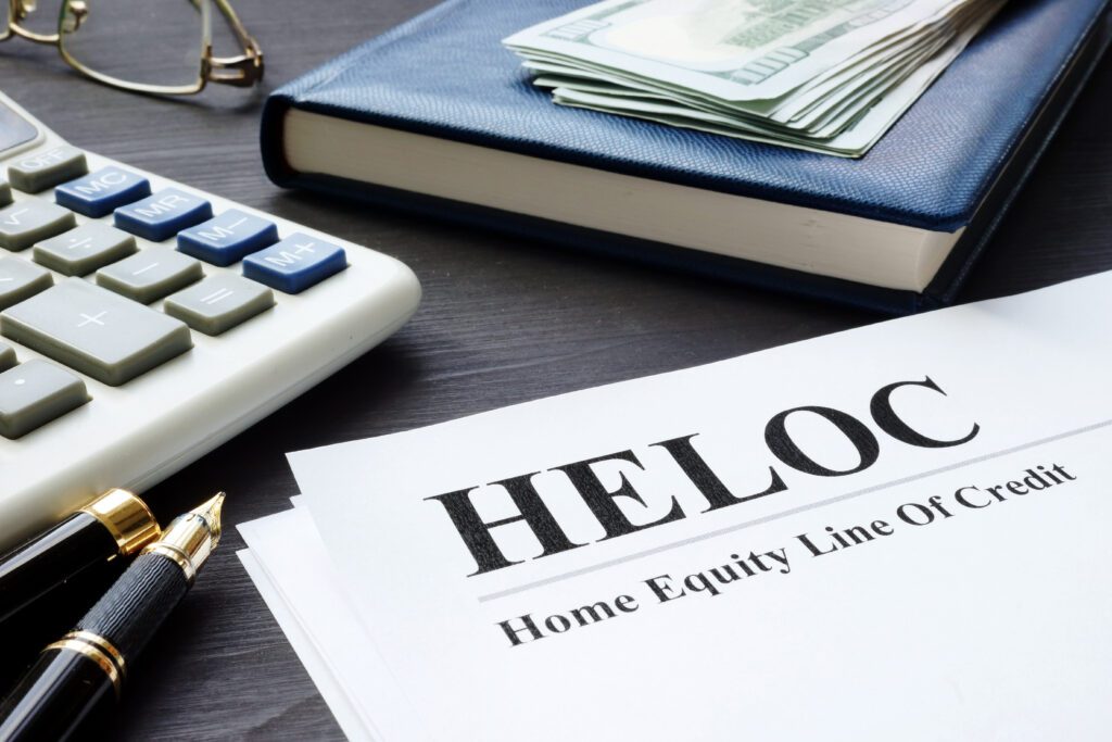 HELOC paperwork rests on desk next to calculator and pens | Home repair financing