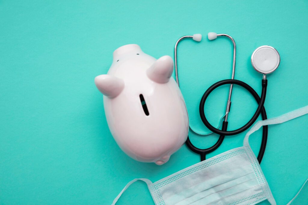 A pink piggy bank next to a stethoscope | How do medical loans work?