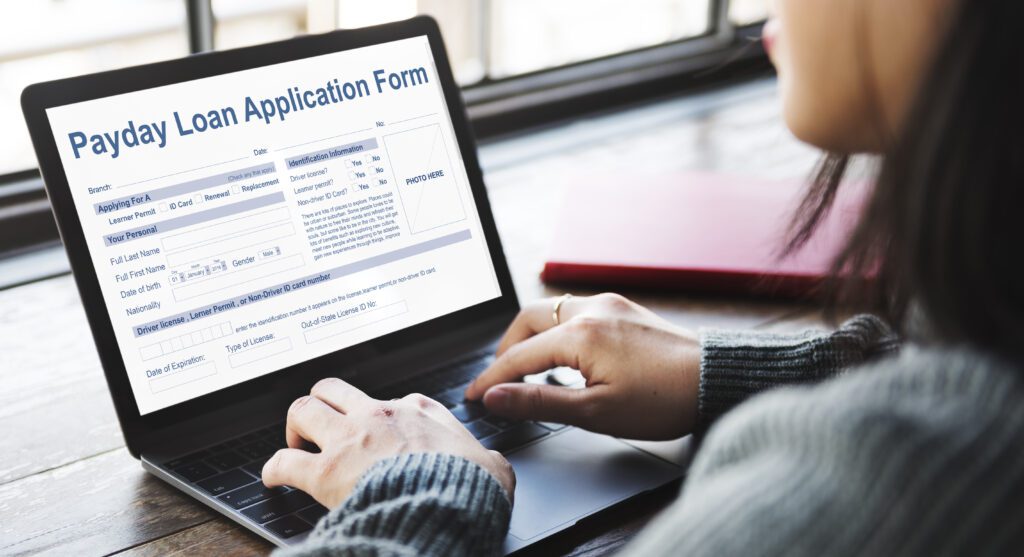 Woman filling out payday application form on laptop computer | Relocation financing options