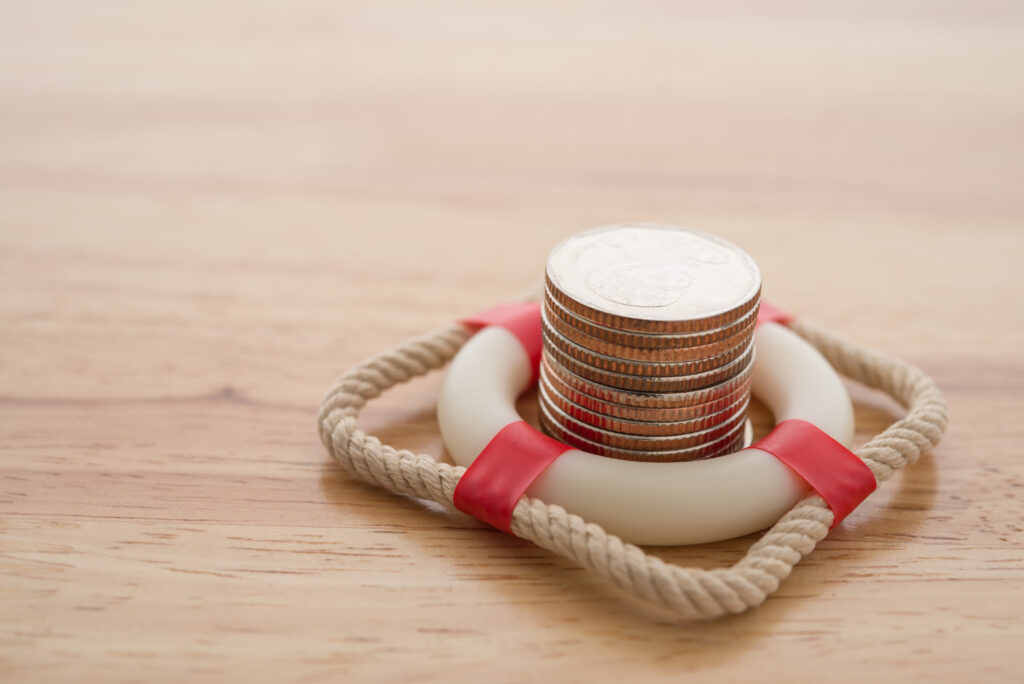 Coin stack surrounded by life preserver on yellow background | 9 types of emergency loans