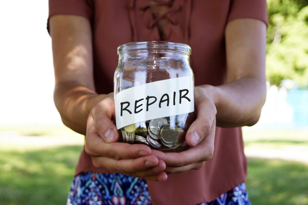 Person holds jar full of coins labeled as repair | How to get a home repair loan