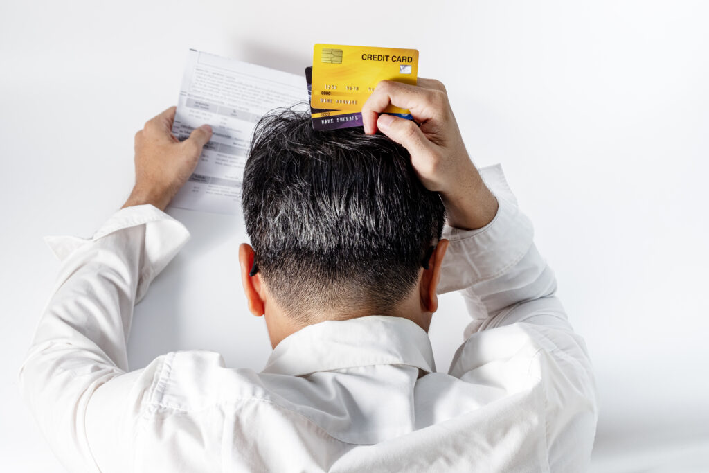 Stressed man holding credit cards grabs head in frustration while looking at credit score | Best installment loans for bad credit