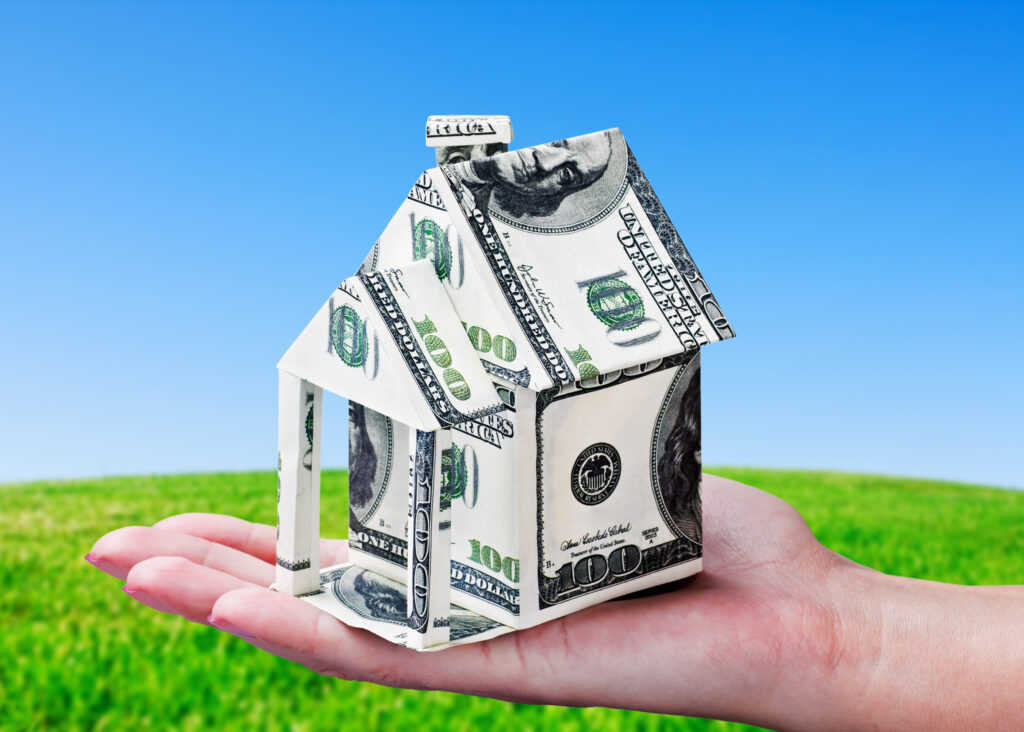 Palm holding a model home made out of folded dollar bills | 9 types of emergency loans