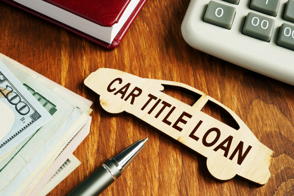 Small wooden car figure labeled as title loan sits on cluttered desk | 9 types of emergency loans
