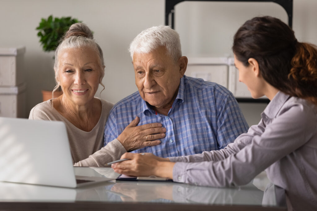 Elderly man reviews his finances with family members on laptop | Ways to get emergency money