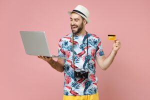 Man wearing vacation shirt and sun hat smiles while booking a vacation | Best Vacation Loans