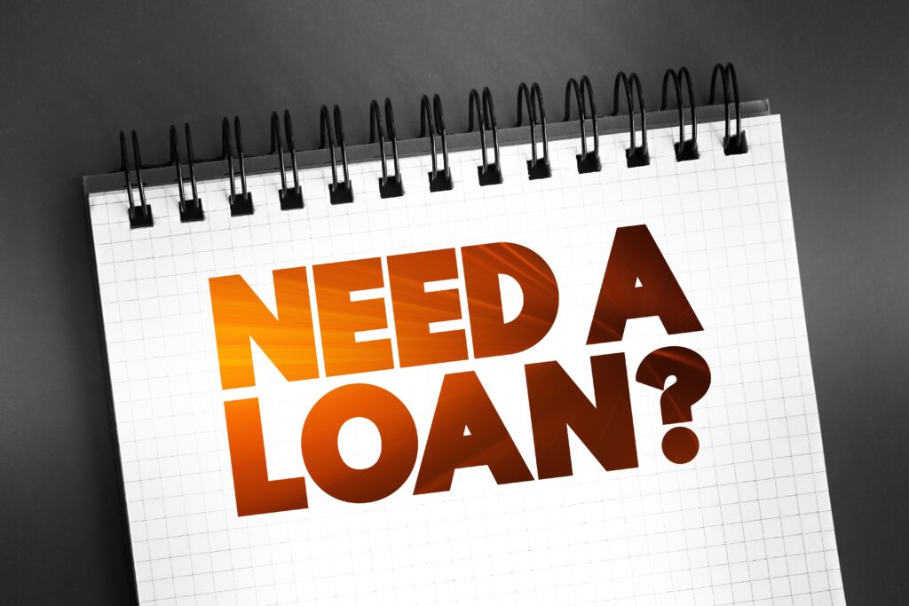 A notebook with the phrase, “Need a loan?” over a black background | Loans like Upstart