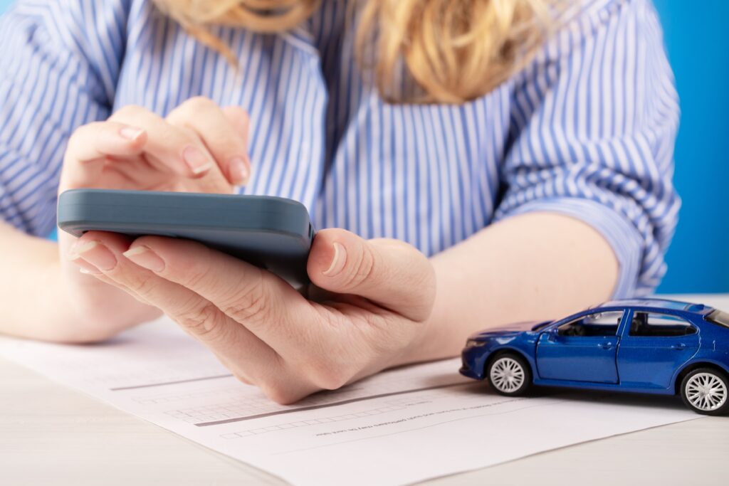 Une femme remplissant une demande de prêt pour réparation automobile sur un smartphone |  Statistiques sur les prêts personnels
