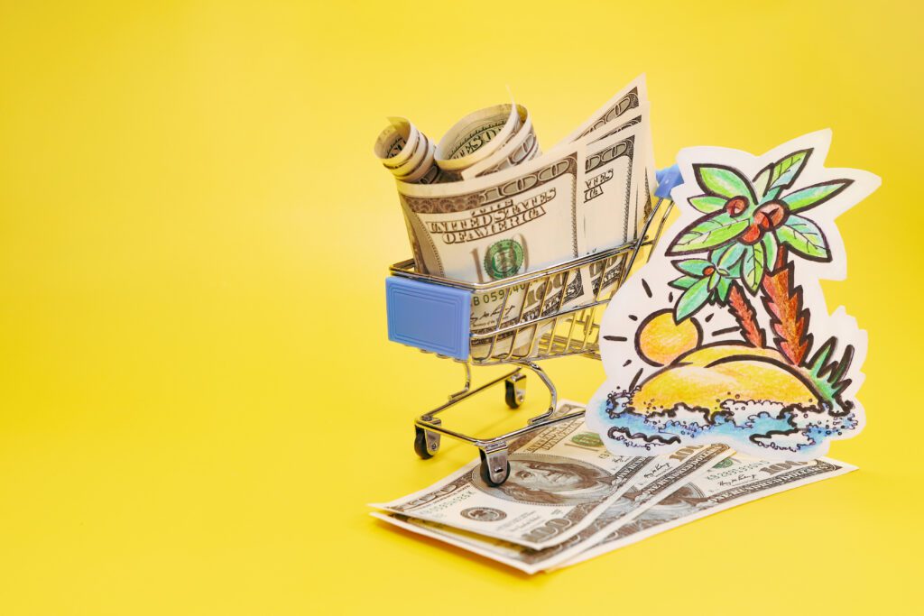 Shopping cart full of cash sits over a yellow background and palm tree sticker | Best Vacation Loans
