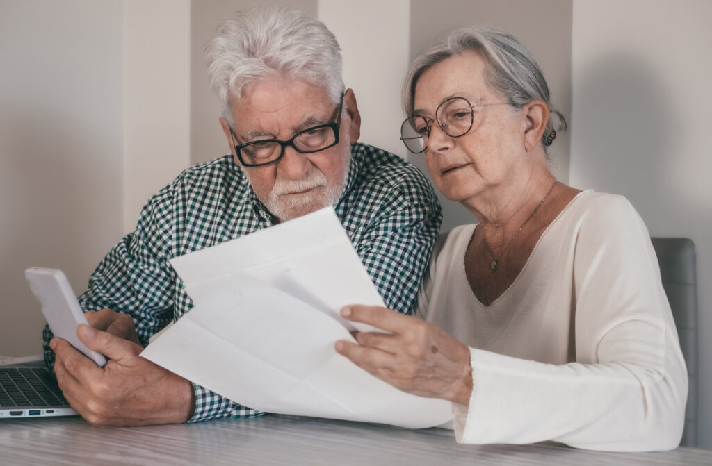 Elderly couple reading loan agreement.