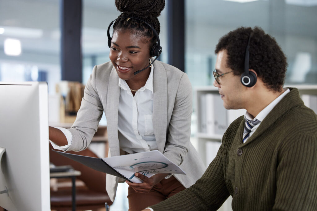 Two customer service representatives assisting customers on the phone.